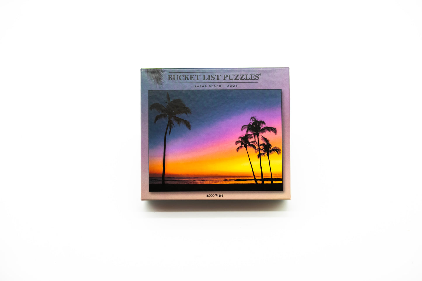 Box of Bucket List Puzzles with a sunset and palm tree design on a white background