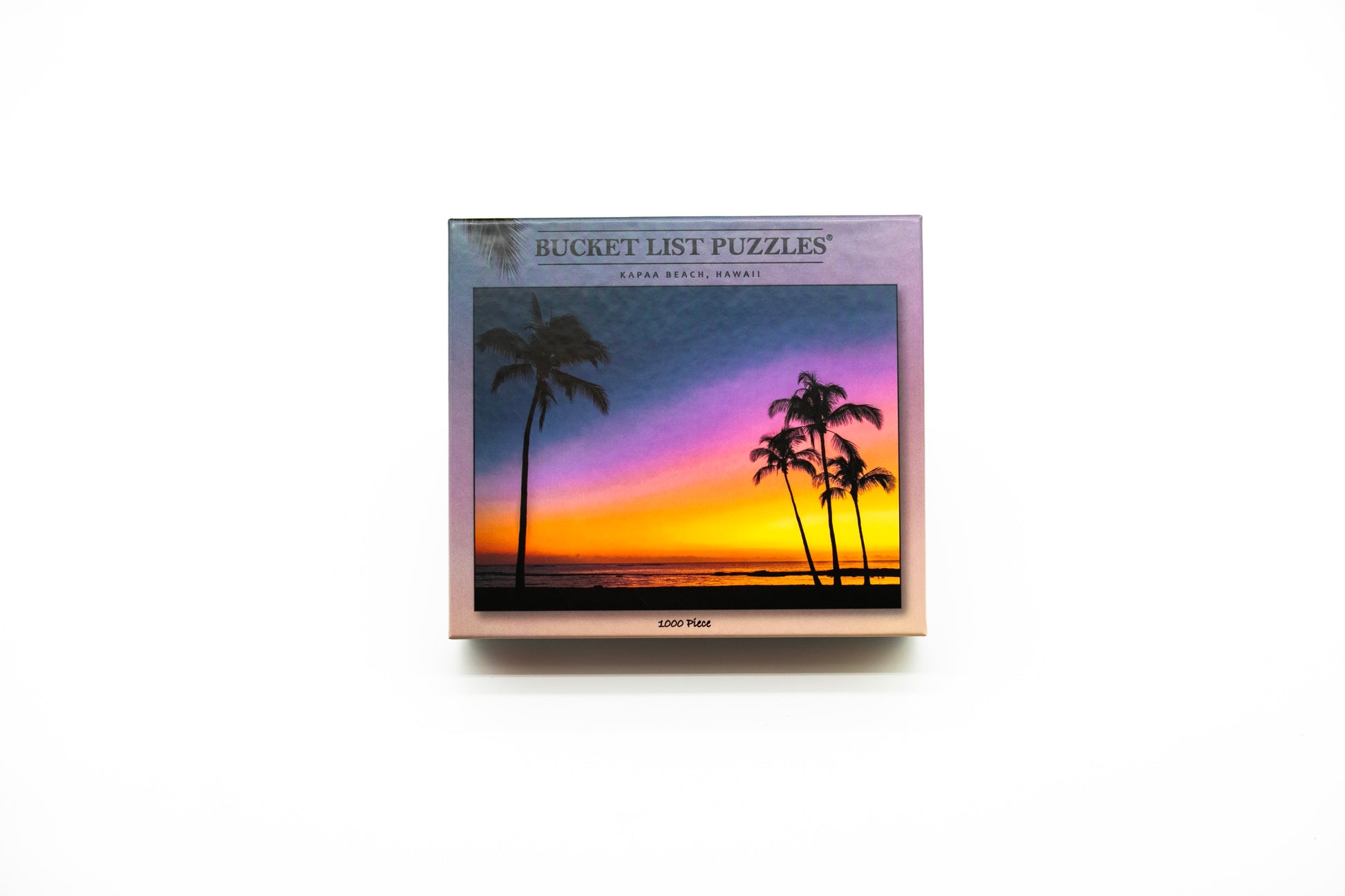 Box of Bucket List Puzzles with a sunset and palm tree design on a white background