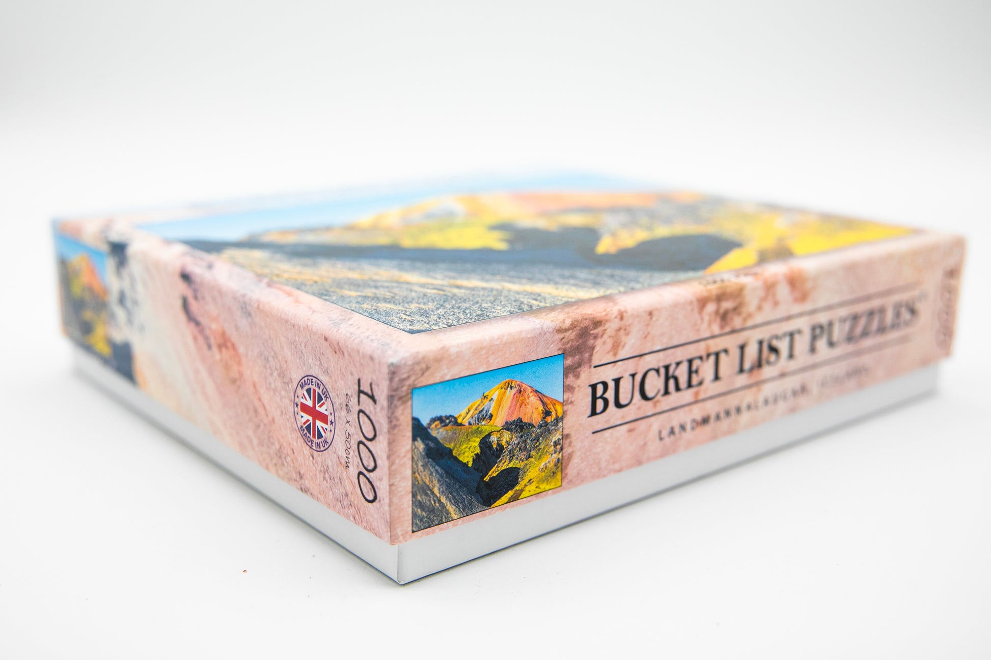 Box of 'Bucket List Puzzles' with mountain and nature-themed images on a white background