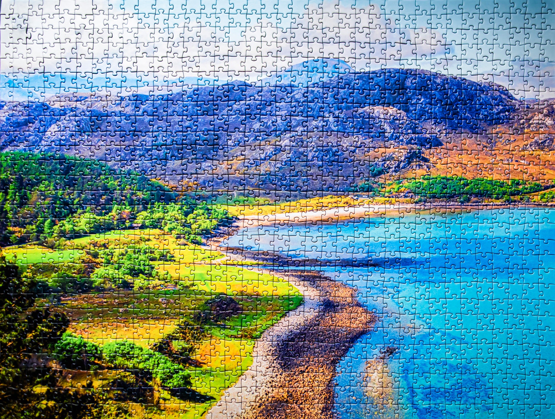 Jigsaw puzzle with a scenic landscape featuring mountains, trees, and a lake.